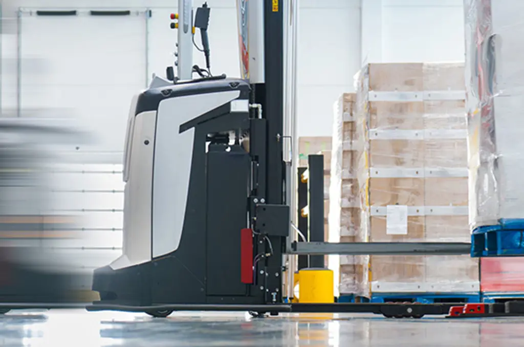 Ein AGV transportiert eine Palette in einem Lager zur automatisierten Materialhandhabung