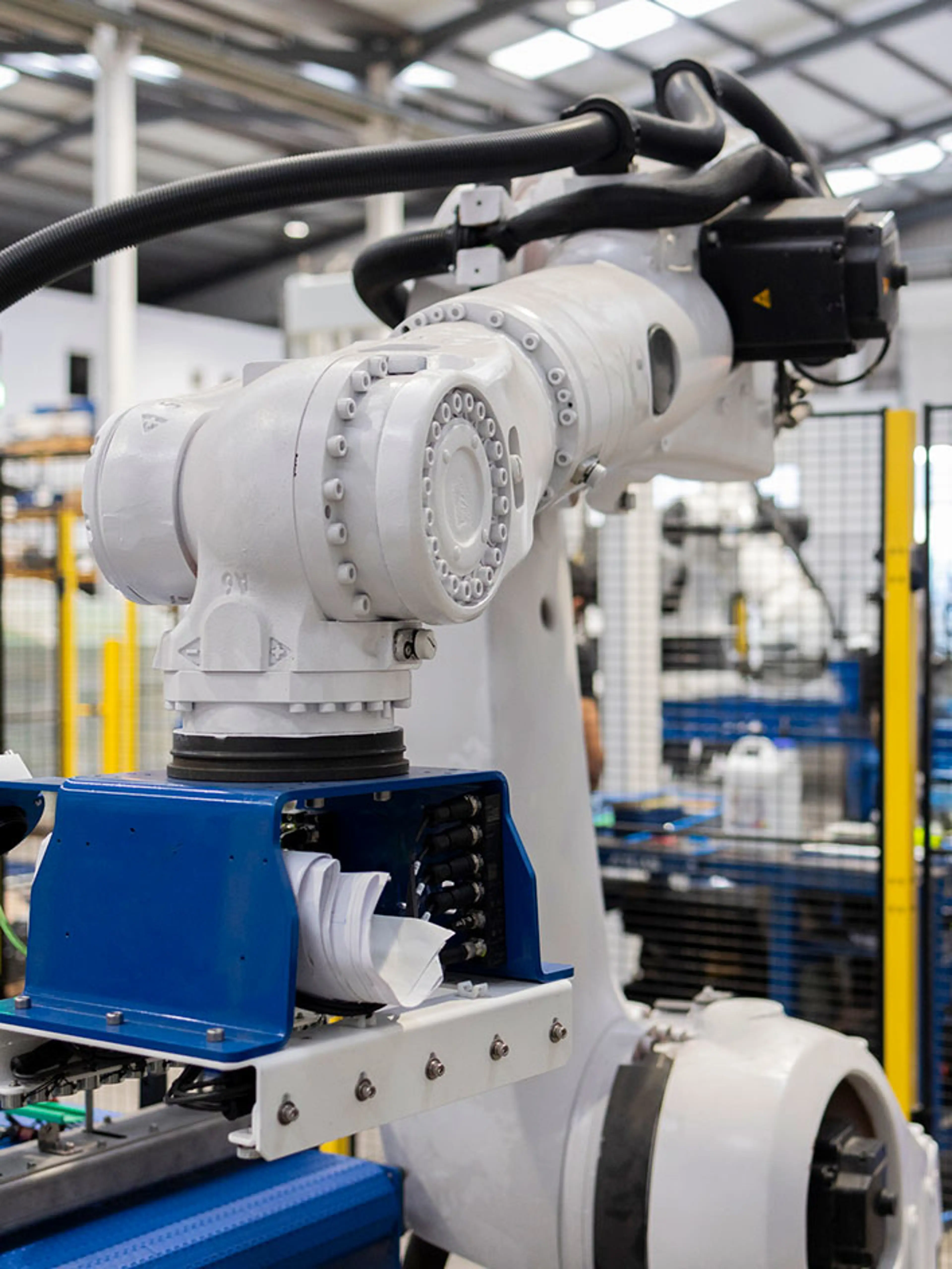 Kollaborativer Roboter platziert Pakete in einem Lager mit Sicherheitsbarrieren.