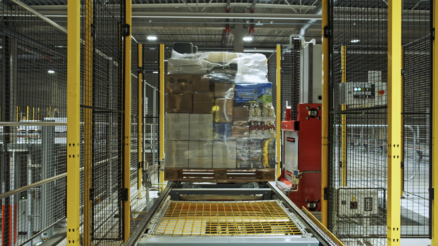 Pallet of goods on automated conveyor inside Axelent's safety fences