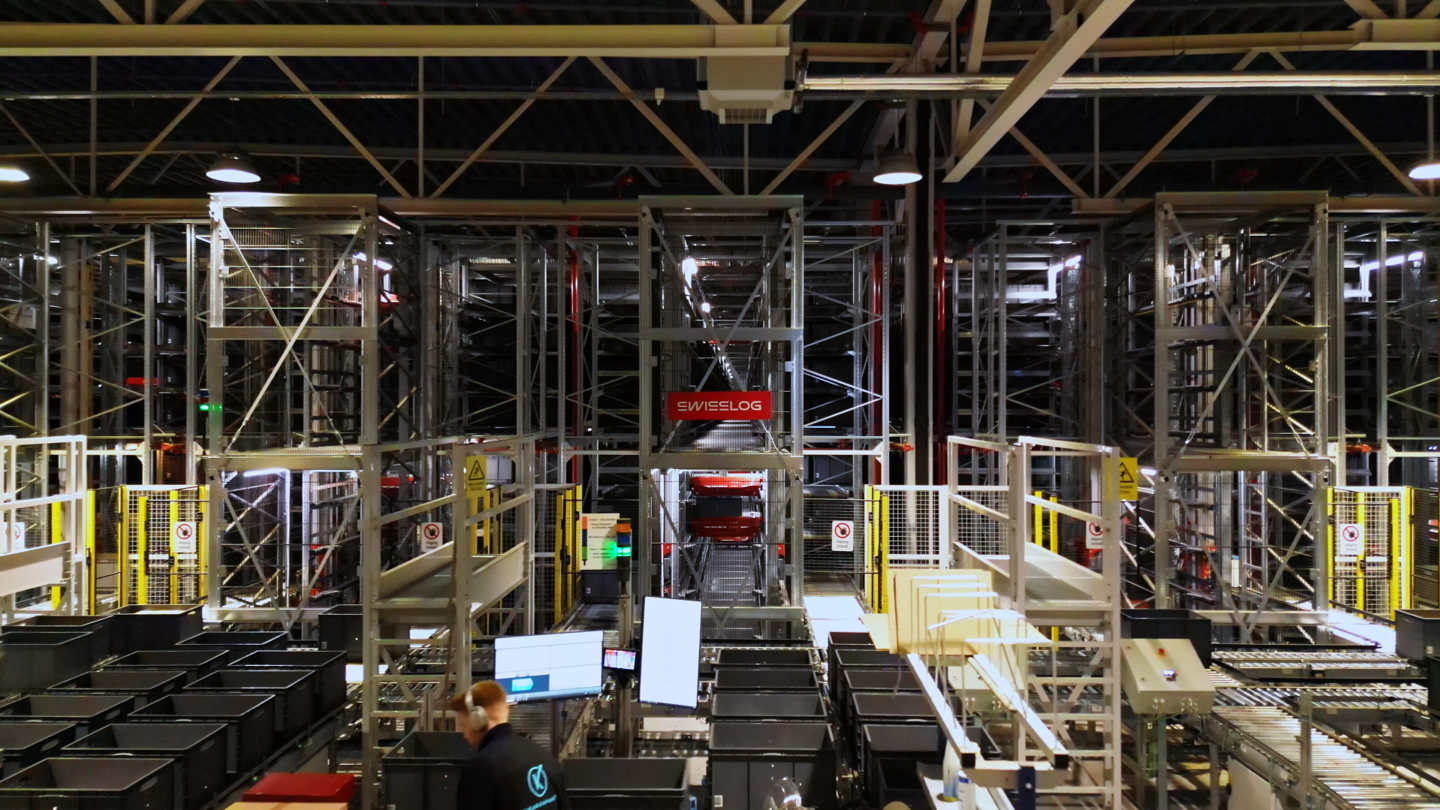 Automated warehouse with Swisslog racking system and conveyor area with machine guarding in front