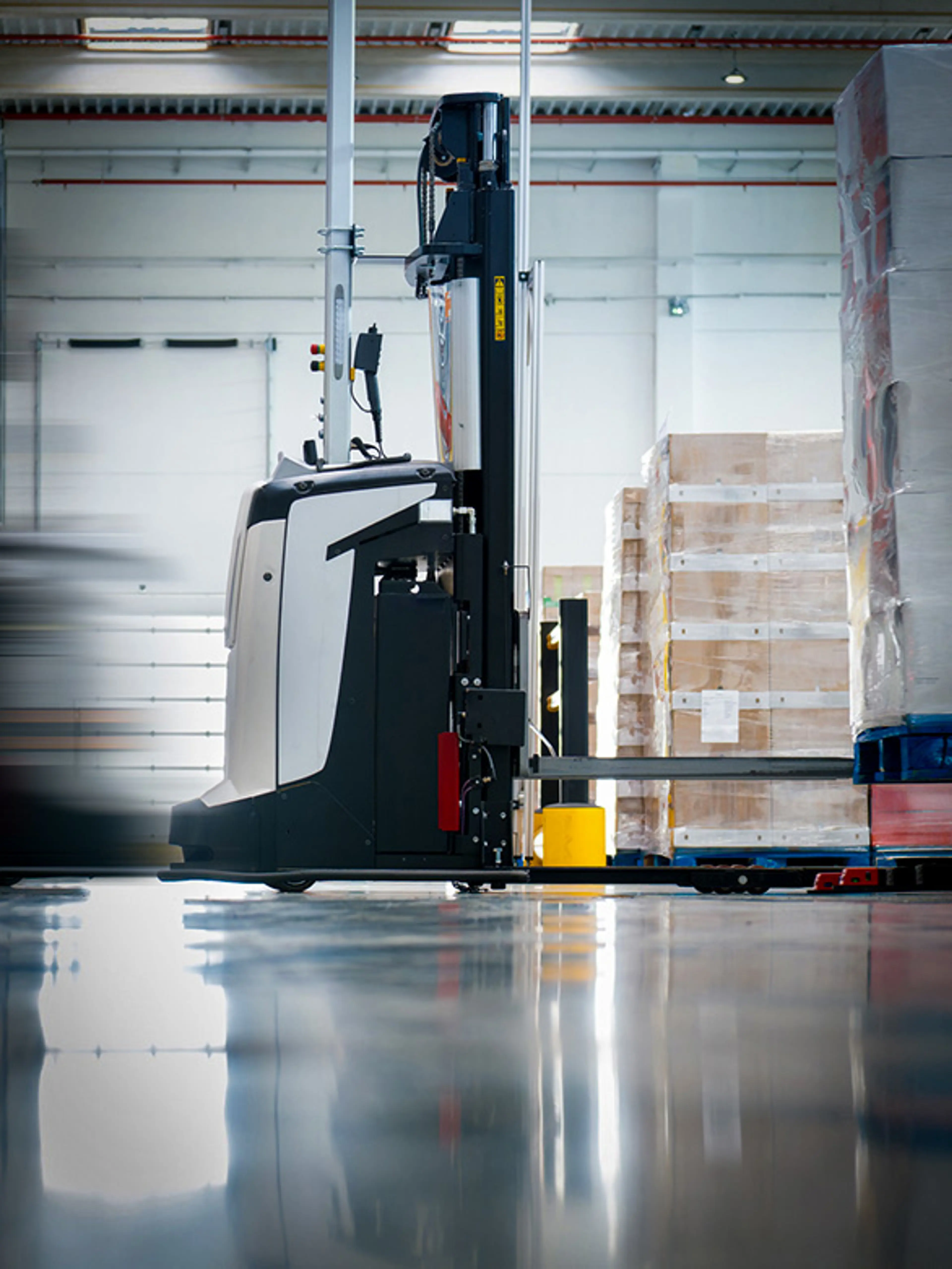 Ein AGV transportiert eine Palette in einem Lager zur automatisierten Materialhandhabung.